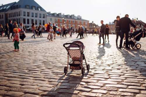 An empty stroller in a crowded Old Town square