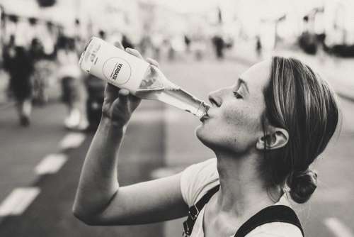 Female drinking soda from a glass bottle