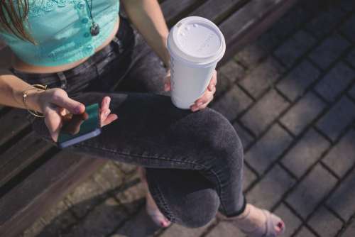 Girl holding phone and coffee