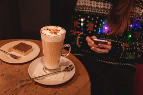 Girl in Christmas sweater sitting in a cafe