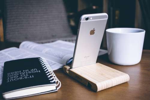 iPhone in a wooden phone holder
