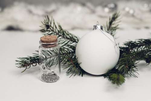 White and silver bauble with a spruce twig