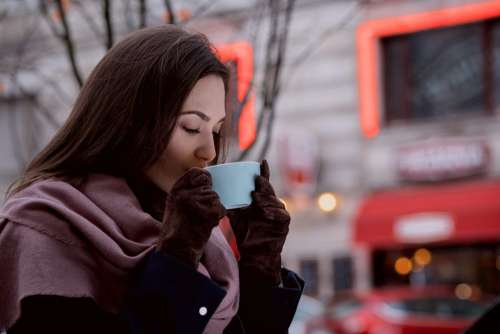 A woman drinking coffee outdoors