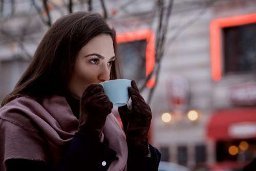 A woman drinking coffee outdoors 2