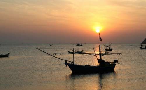 Boats in the ocean at sunset in Thailand free photo