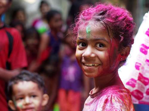 Child with paint on her in Mumbai, India free photo