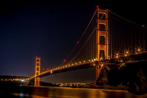 Golden Gate Bridge over the bay at night illuminated in Gold in San Francisco, California free photo