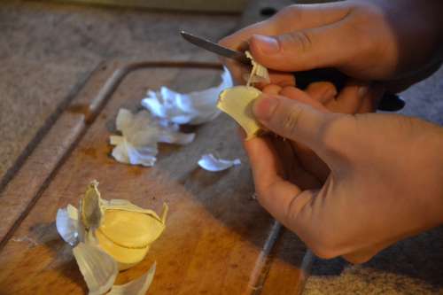 Hands Peeling Garlic with knife  free photo