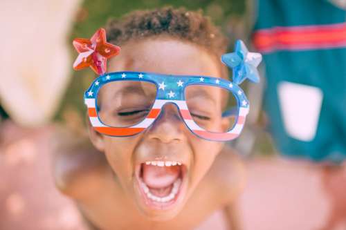 Kid Celebrating 4th of July with red white blue glasses free photo