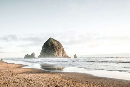 Large Rock rising out of the sea at Cannon Beach, Oregon free photo