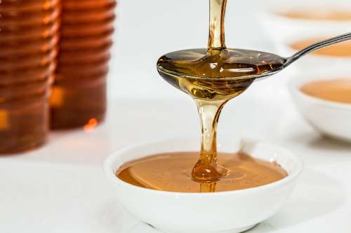 Pouring Honey on spoon and bowl free photo