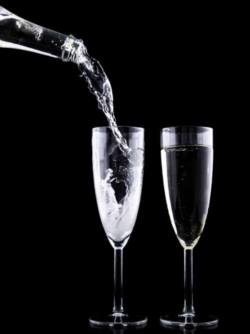 Pouring two cups of sparkling wine free photo