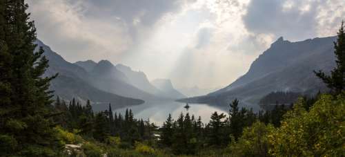 Sunlight from above the clouds over the lake at Glacier National Park, Montana free photo