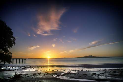 Sunrise on the beach in Auckland, New Zealand free photo