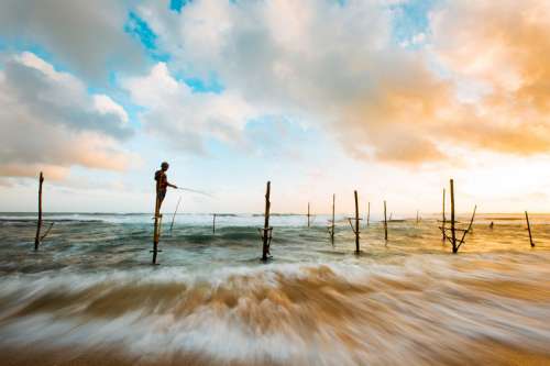 Time-Lapse landscape with fisherman under clouds and sky in Hikkaduwa, Sri Lanka free photo