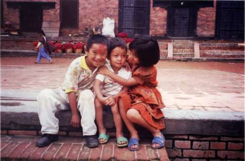 Two kids hugging a smaller kid in Kathmandu, Nepal free photo