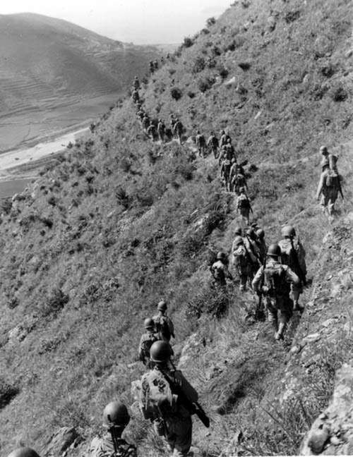U.S. Marines move out over rugged mountain terrain during Korean War free photo