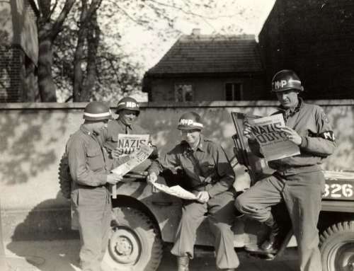 US military policemen read about the German surrender ending World War II in Europe free photo