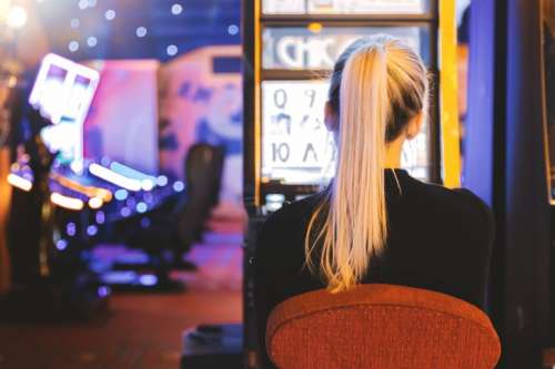 Young woman playing at slot machine in casino
