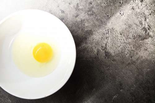 Fresh egg in white bowl from the top