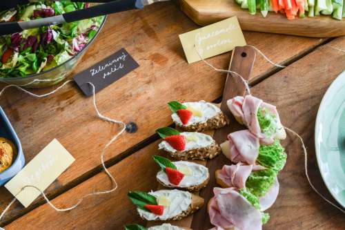 Mix of sandwiches and vegetable salad on wooden table