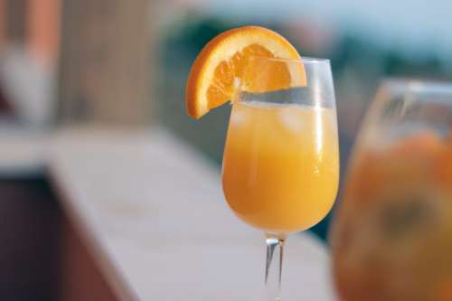 Orange juice in glass with piece of orange