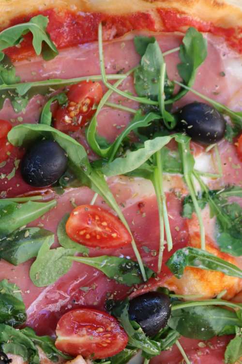 Italian pizza with tomatoes, olives and rucola