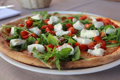 Pizza with rucola, mozzarella and tomatoes