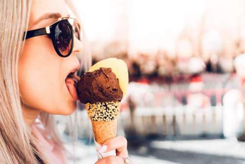 Happy Girl Licking Chocolate Ice Cream in Summer