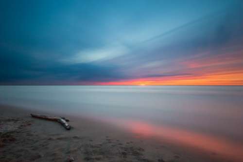 Beach Driftwood Sunset Ocean Calm Waters Colorful