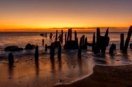 Waves Wooden Poles Ocean Beach Sunrise Sunlight