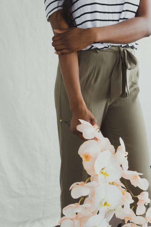A Model In Khakis Holding Orchids Photo