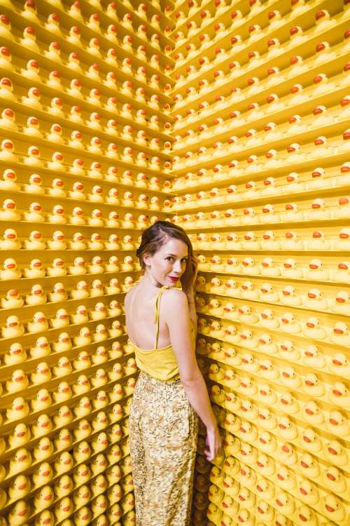 Model Posing Coyly With Hundreds Of Rubber Ducks Photo