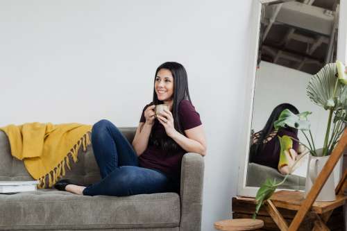 Woman Cradles Coffee On A Sofa Photo