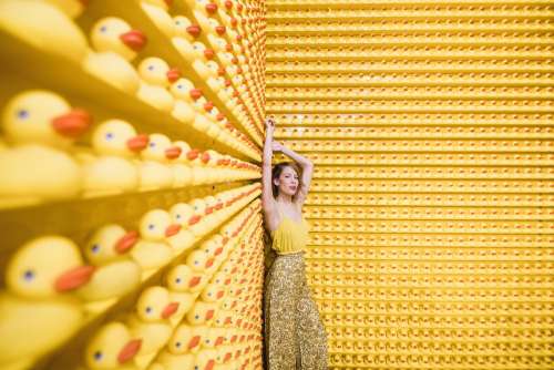 Woman In Yellow With Rows Of Rubber Ducks Photo