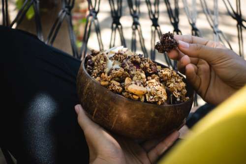 Girl eating granola bites with nuts and coconut flakes