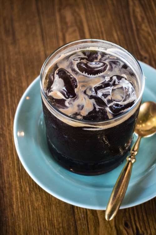 Iced black coffee with golden spoon