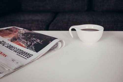 Cup of coffee and a newspaper on the table 2
