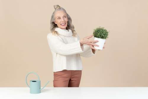 Old Woman Holding A Plant
