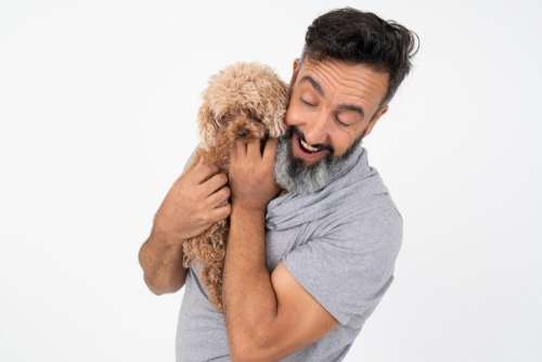 Contented Mature Man Holding A Puppy