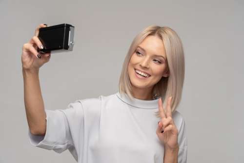 Young Attractive Woman Holding Vintage Camera Like Doing Selfie