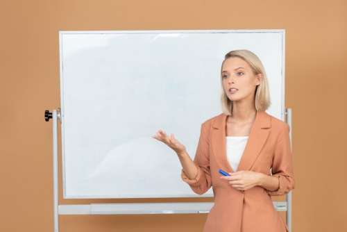 Attractive Young Woman Explaining Something Near The Whiteboard