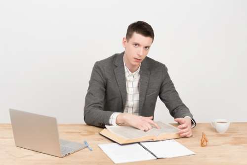 Young Handsome Teacher Showing A Line In The Book