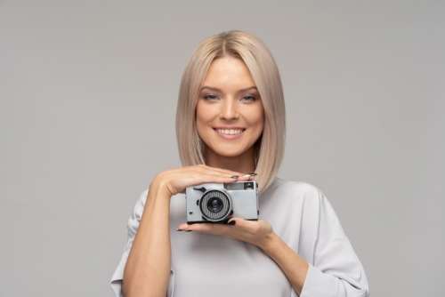 Young Attractive Woman Holding Camera Between Her Hands