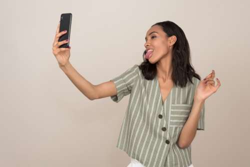 Young Attractive Girl Taking A Selfie With Her Tongue Out