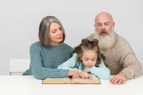 Grandparents And Kid Girl Granddaughter Reading A Book