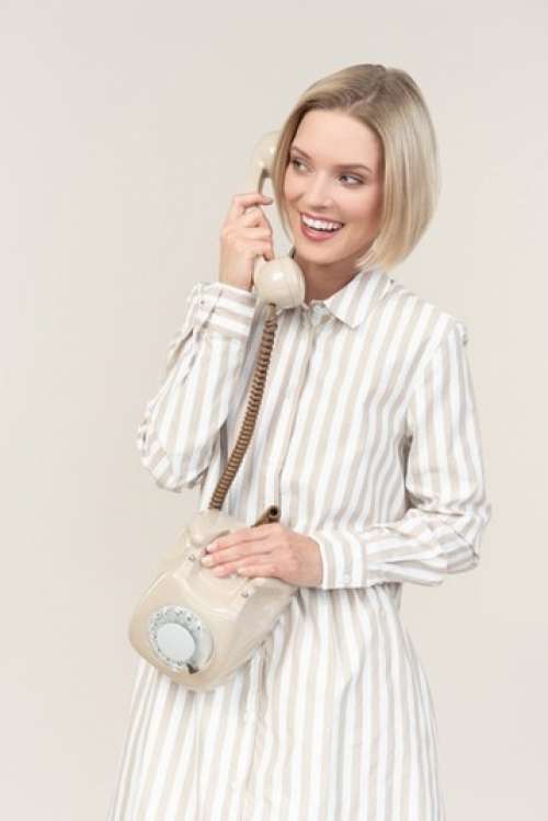 Smiling Young Woman Talking On The Old Rotary Phone