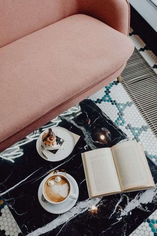 Laptop, coffee and cake with meringue and whipped cream on black marble