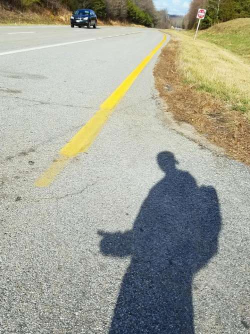 hitchhike travel road shadow man