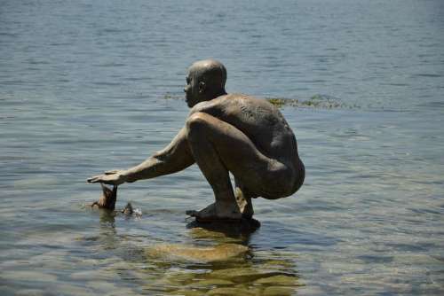 Sculpture primitive man lake of constance water germany